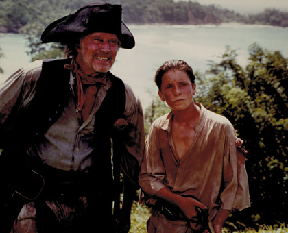 Long John Silver (Charlton Heston) and Jim Hawkins (Christian Bale)